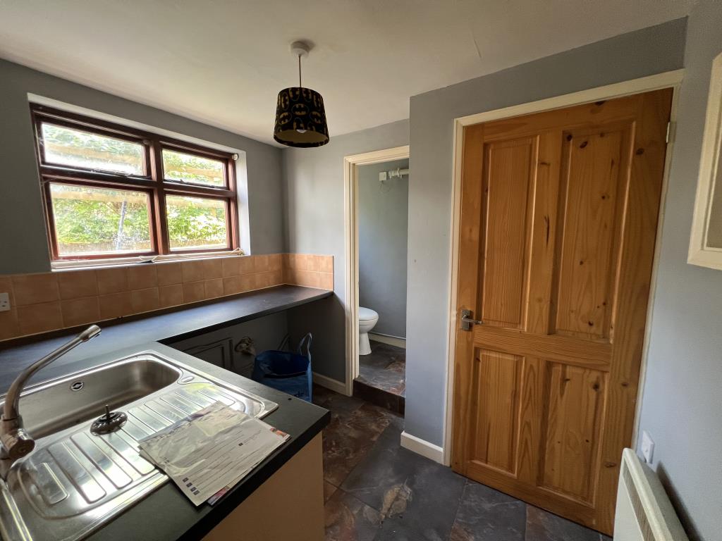 Lot: 93 - COTTAGE FOR REFURBISHMENT - General view of utility room with cloakroom W.C. and Megaflop water tank cupboard